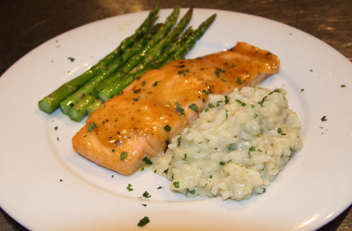 Parmesan and shallot risotto served alongside salmon and asparagus