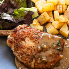 Pork Chops with Beer and Mustard Gravy served alongside potatoes and salad.