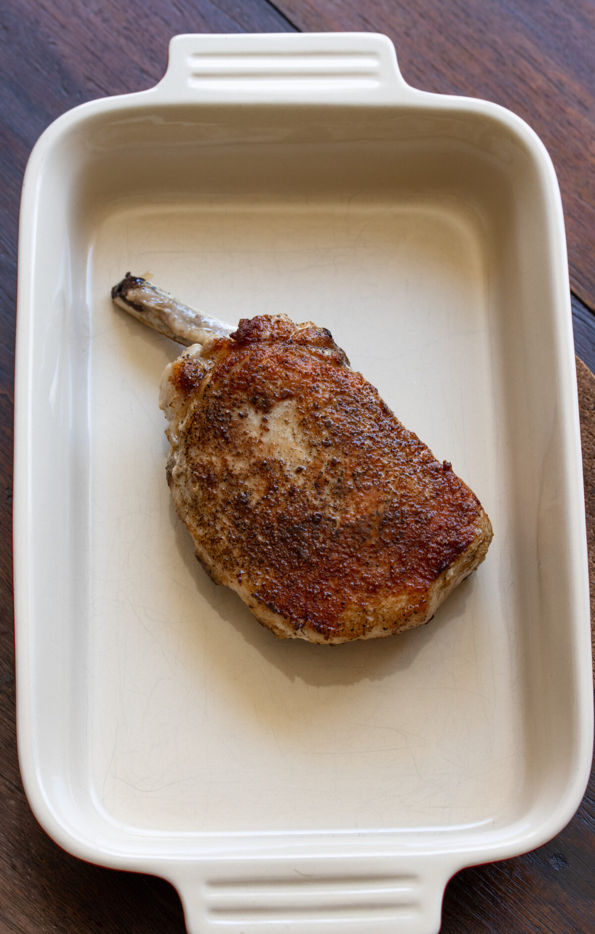 Pork chop transferred into a ovenproof plate to keep warm