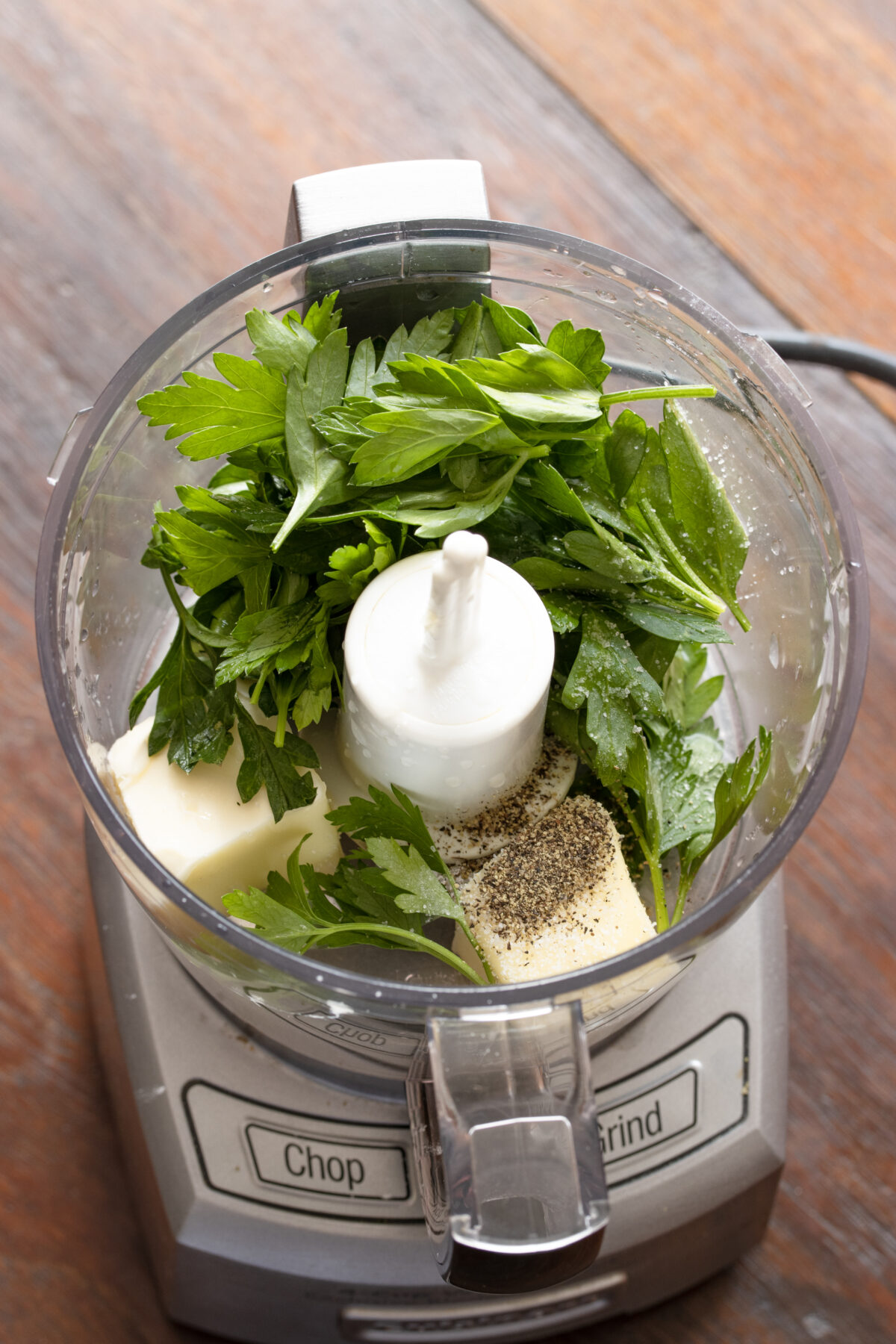 The butter, parsley, lemon juice, and pepper until smooth are placed in a food processor basket. 