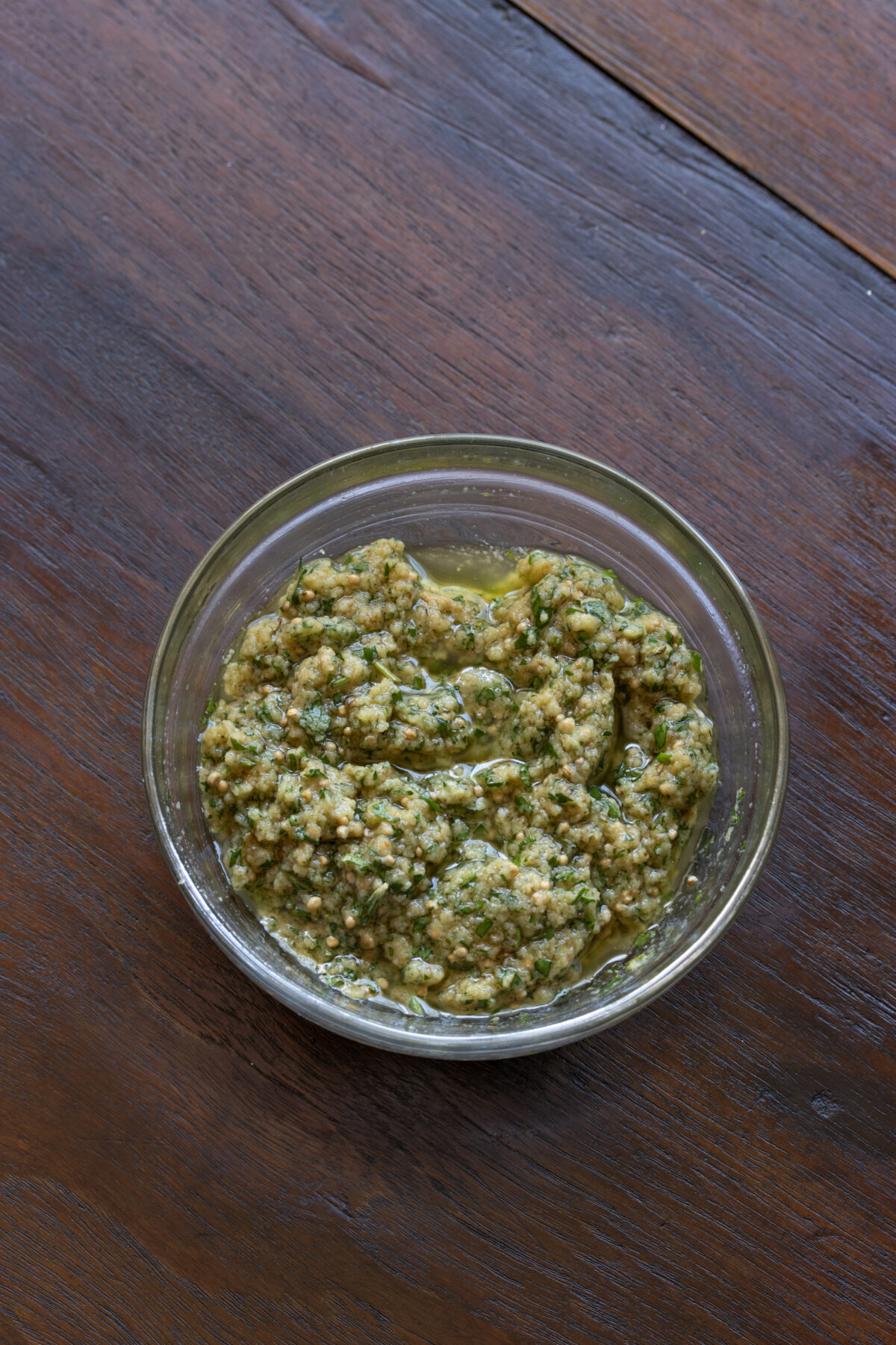 Prepared herb crust in a glass container.