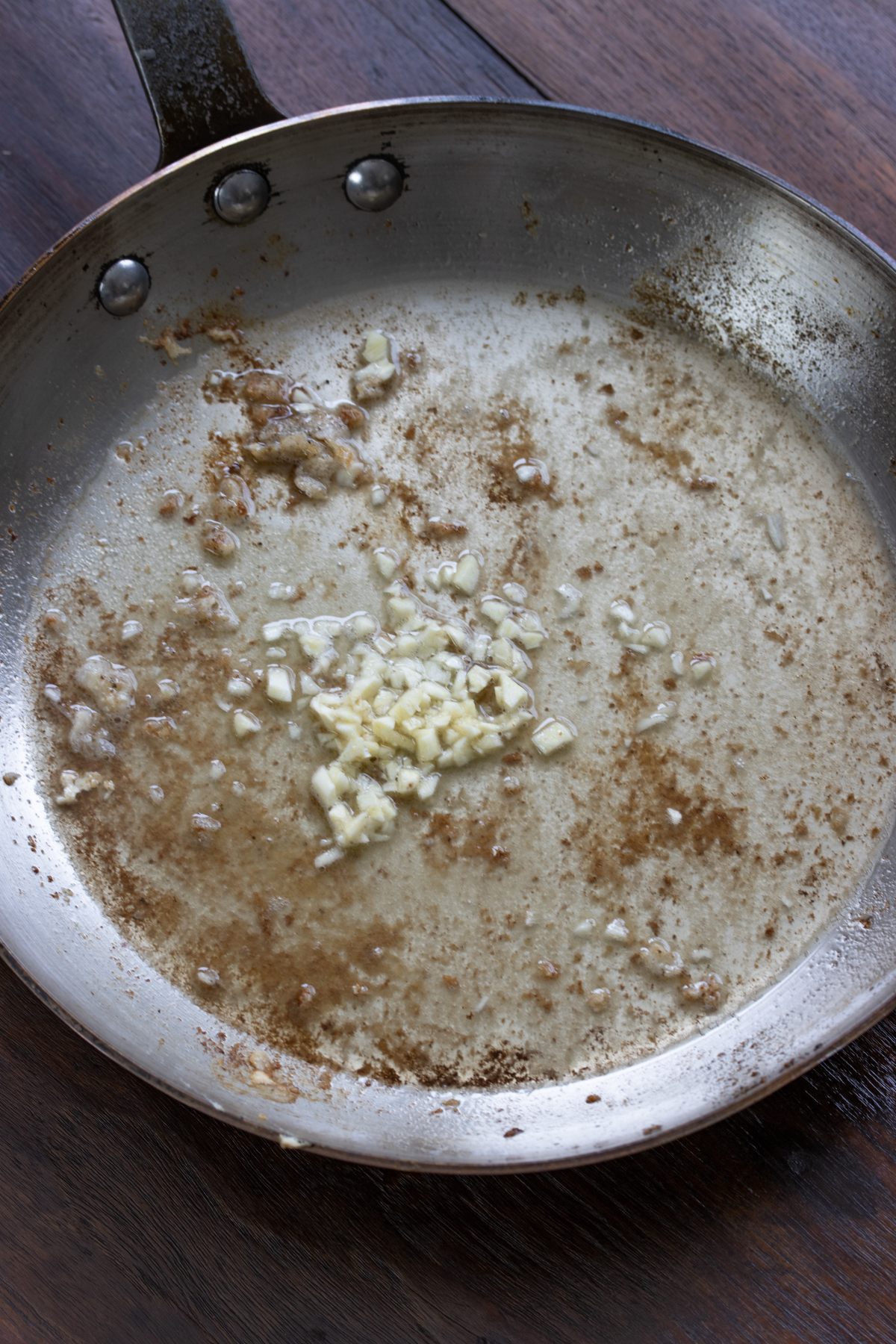 Once the cod is cooked, garlic and white wine are added to the skillet. 