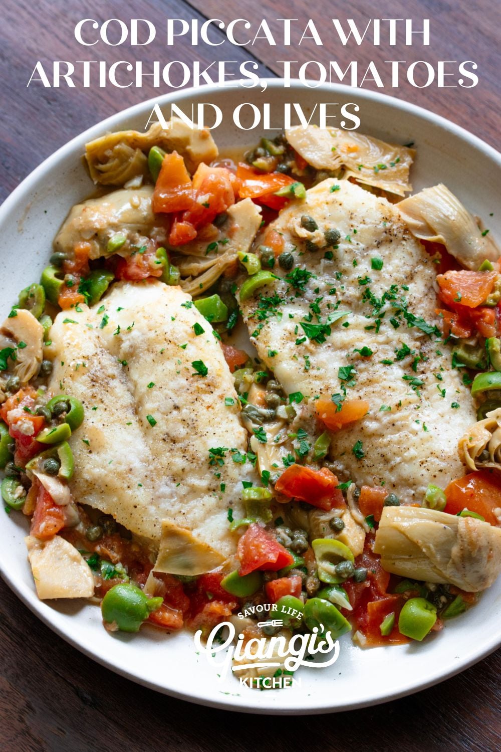 Cod Piccata with Artichokes, Tomatoes and Olives served in a round white dish.
