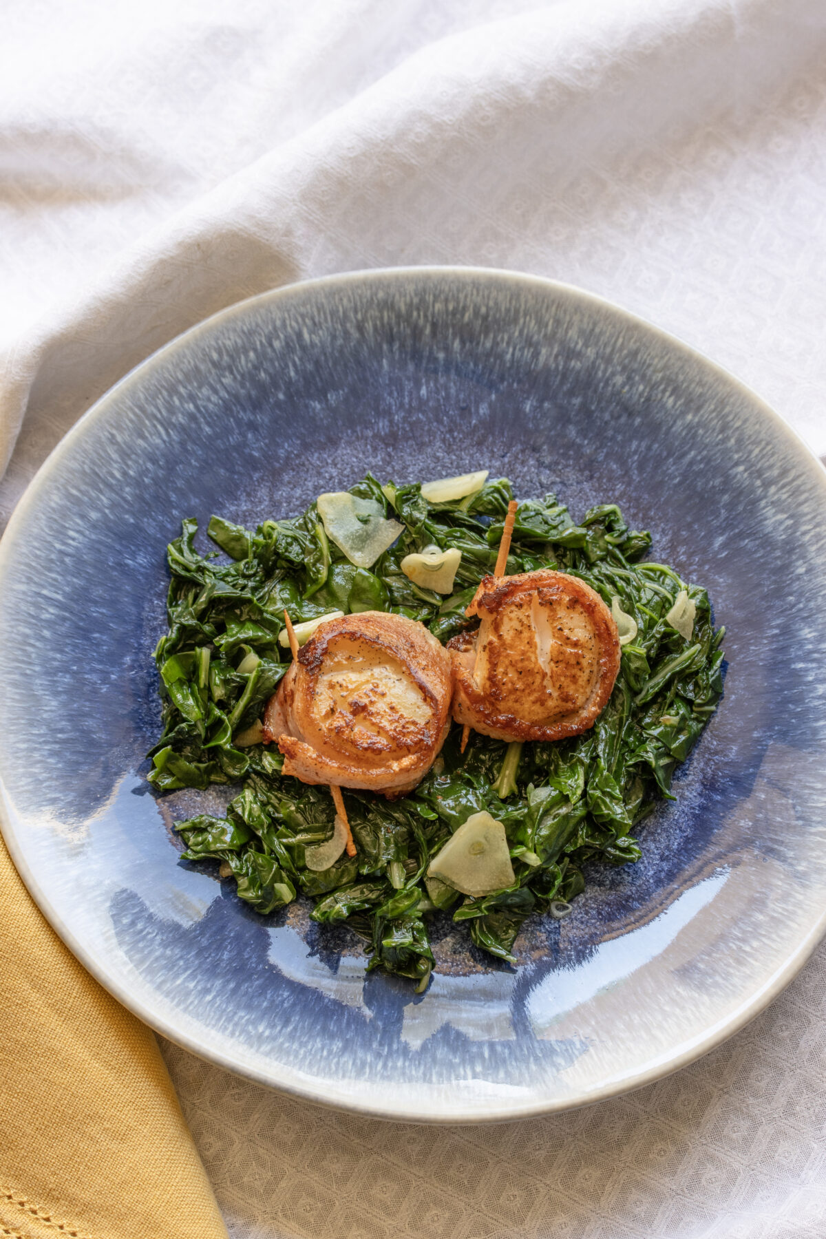 Scallops served over a bed of swiss chard and garlic.