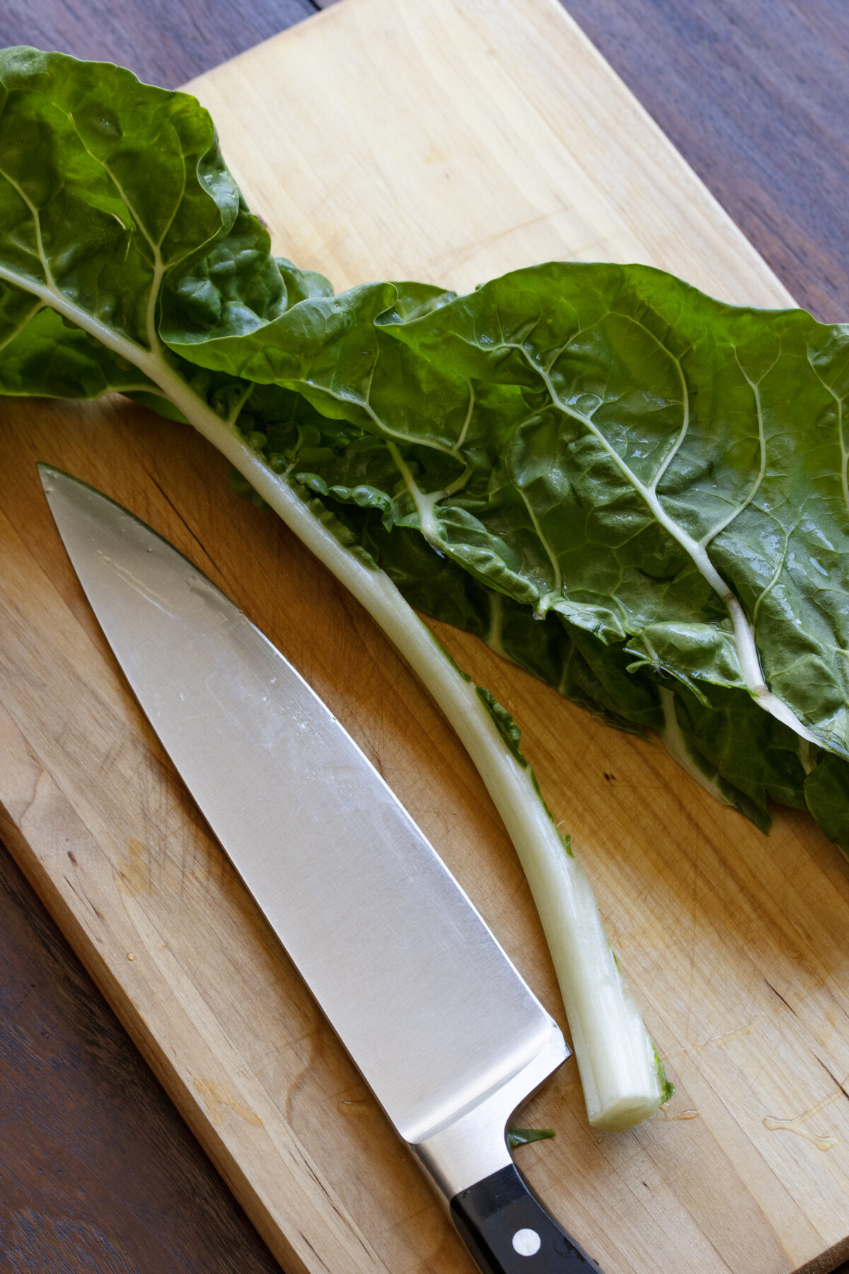 Core of the Swiss chard leaves removed by a chef's knife by cutting on the edge.