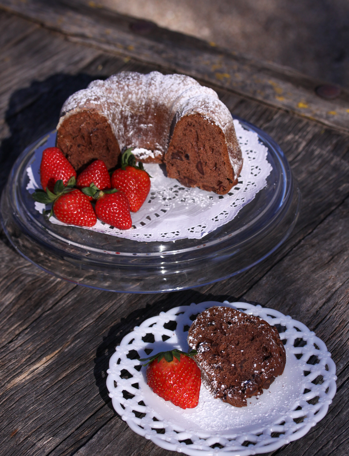 Cake on a cake stand and a slice of chocolate pound cake on a white dish