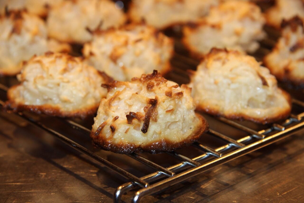 Several Chilean coconut macaroons on a wire cooling rack.