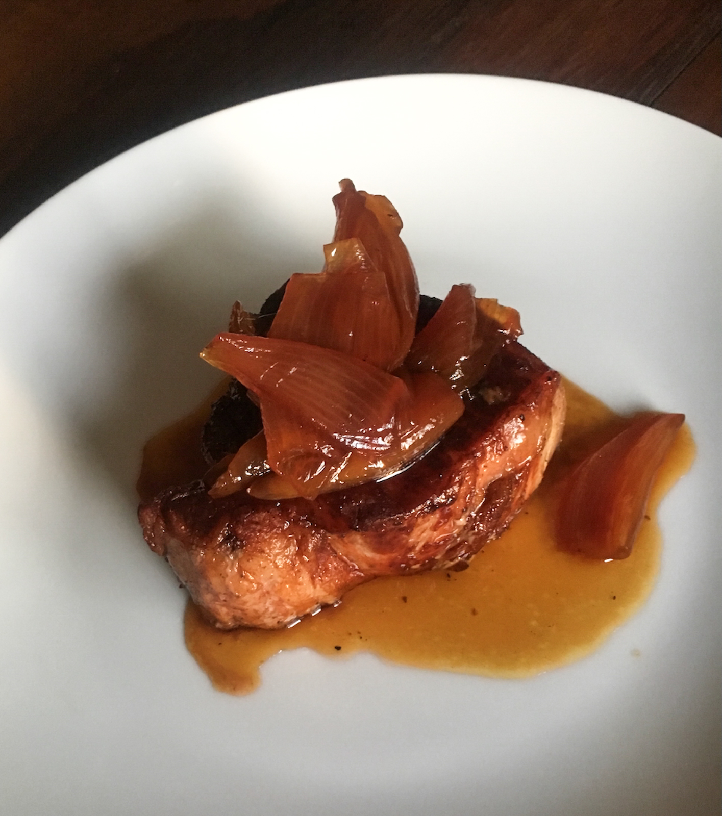 caramelized shallots with NY steak on a white serving plate