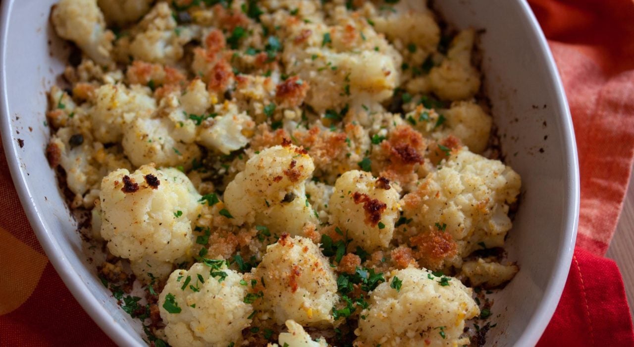 A baking dish full of the recipe served on a red towel.