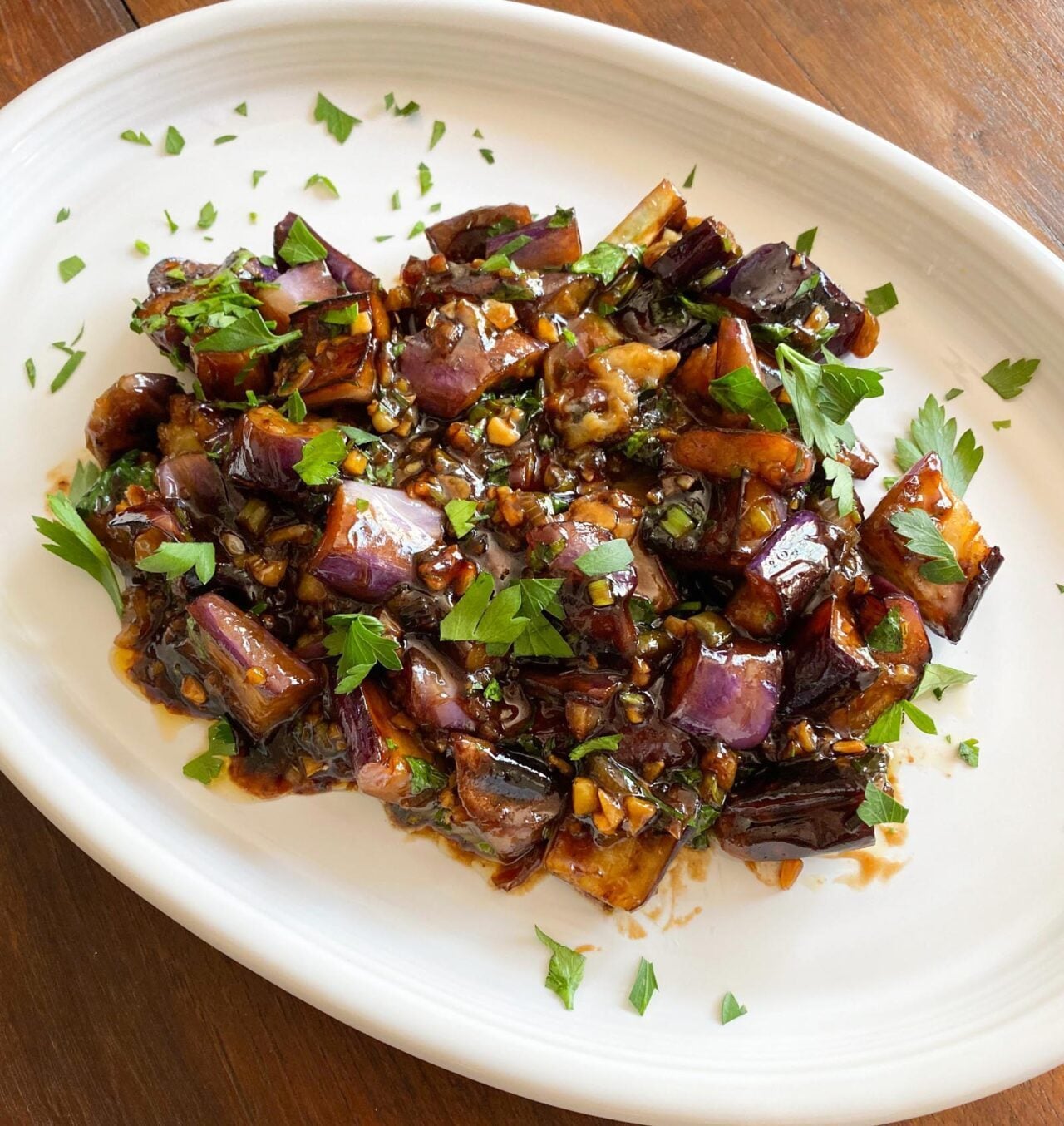 Ready to enjoy eggplant chinese style with sprinkled parsley over it. 