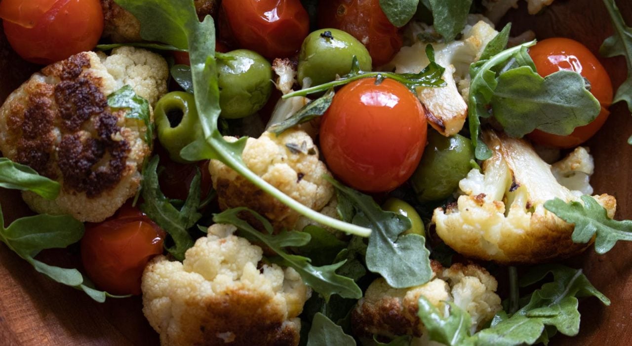 Cauliflower with Olives and Cherry Tomatoes cauliflower with olives and cherry tomatoes served in a wooden bowl