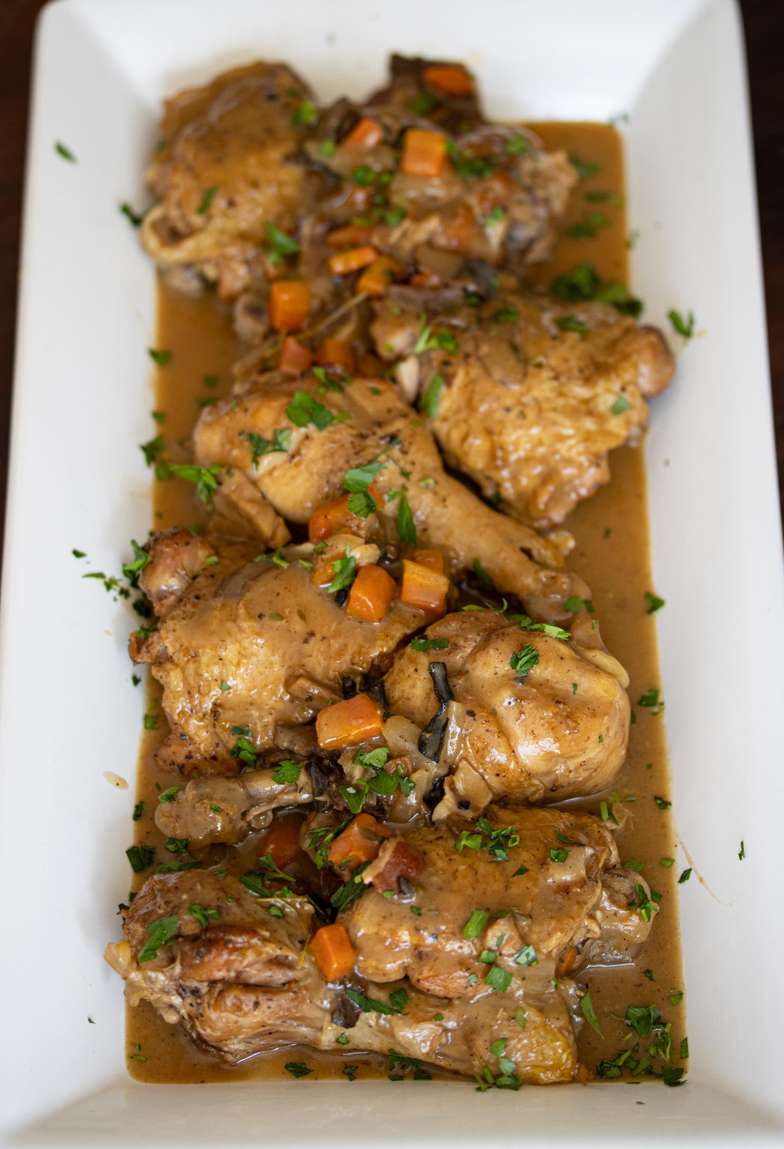 coq au vin blanc Coq au vin blanc served with the juices in a rectangular serving platter.