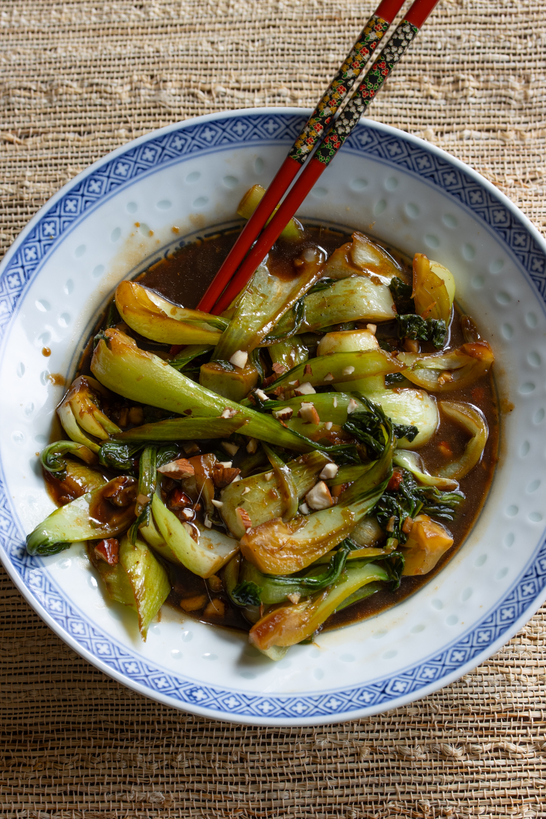 Cooked steamed bok choy in a white and blue chinese serving dish.