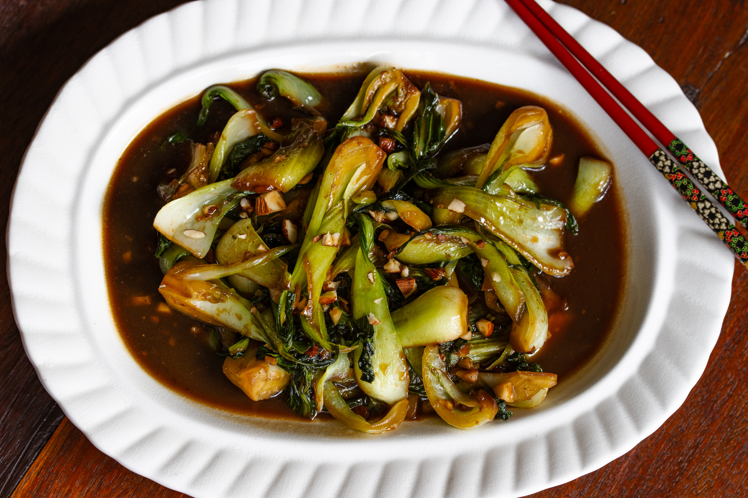 Ready to be enjoyed steamed bok choy in a off white oblong serving dish.
