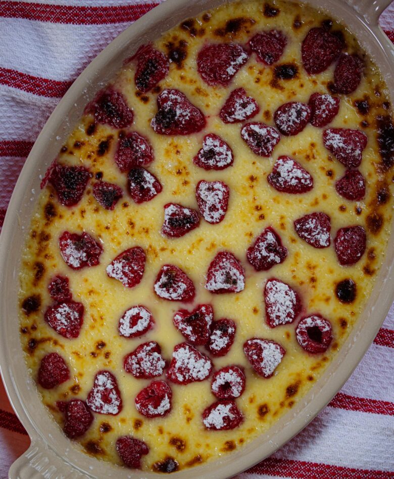 Raspberry gratin served in an oval gratin dish with powdered sugar sifter over it.