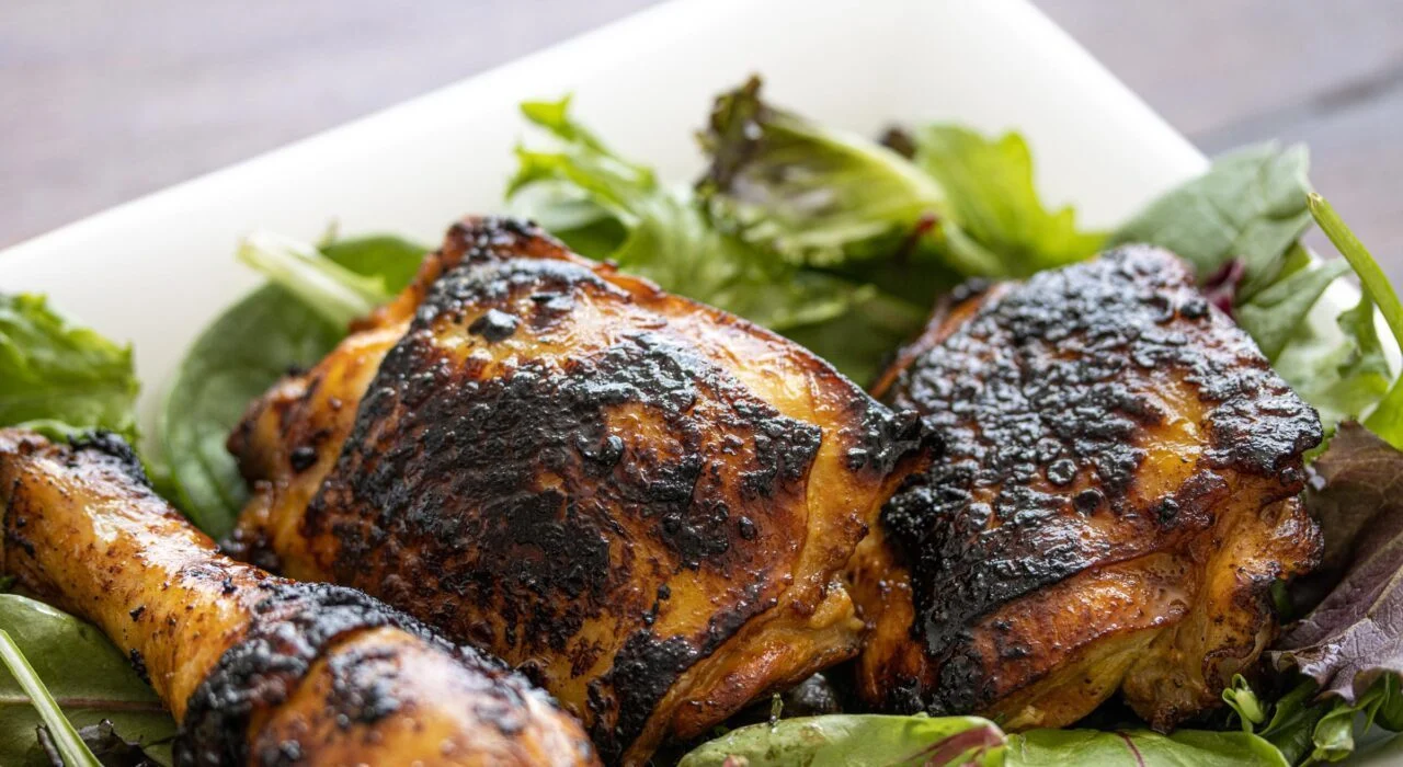 Saffron lemon chicken with Persian Saffron Rice Lemon chicken on a bed of salad on a serving plate.