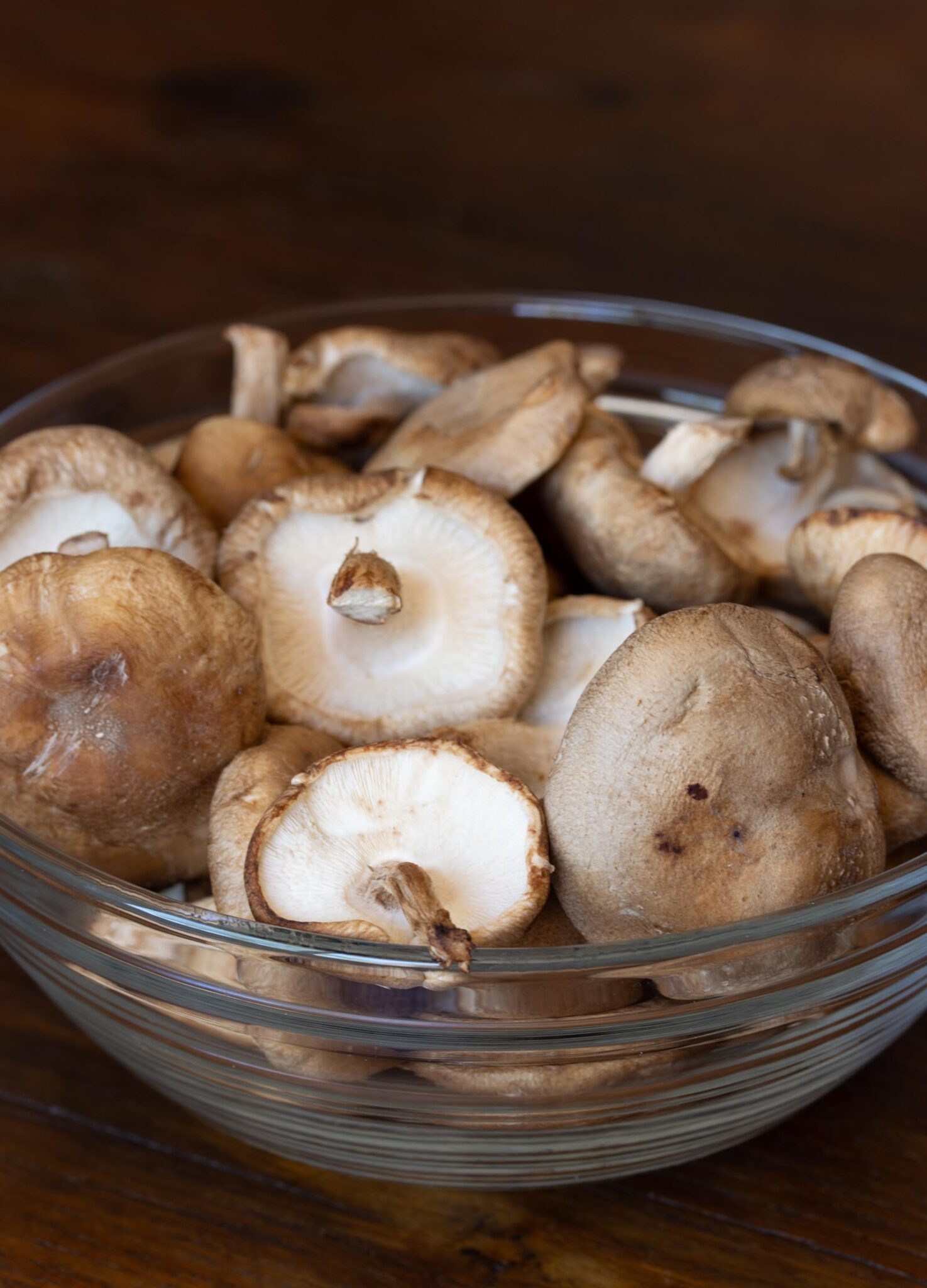 Shiitake mushrooms in a clear bowl before being sliced.