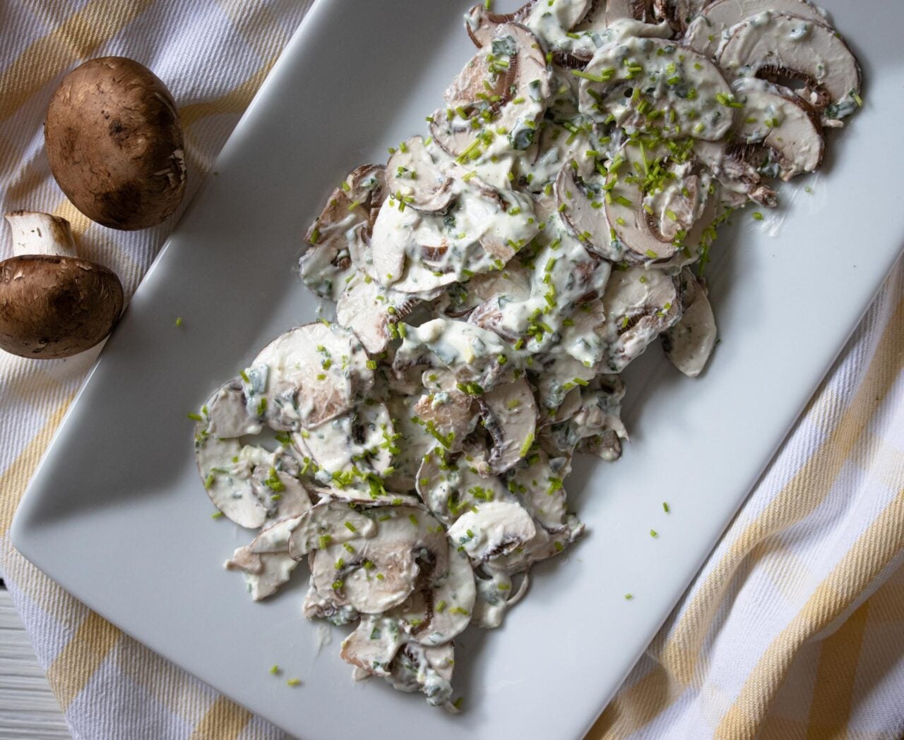 Easy Mushroom Salad With Herbs The finished mushroom salad recipe served on a white plate.