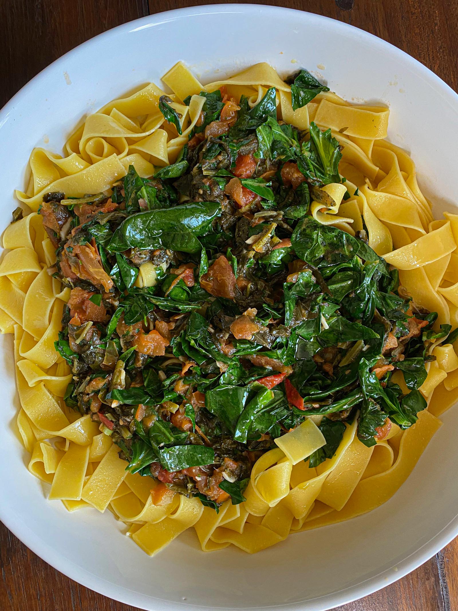 Tomato, Chard, Kale, Spinach with Pappardelle Pasta in a white serving dish