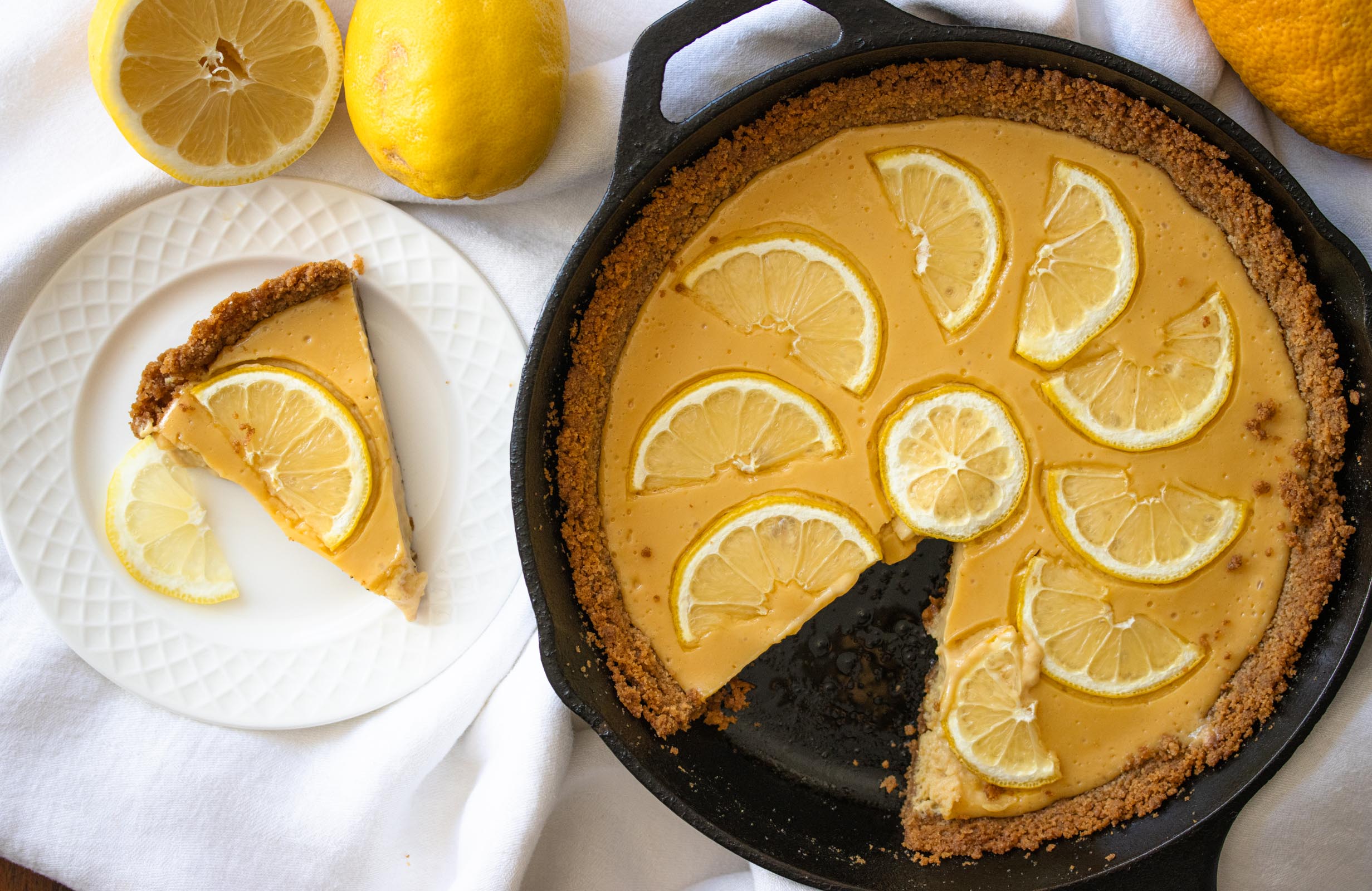 lemon tart A whole piece of tart with a single serving on the side.