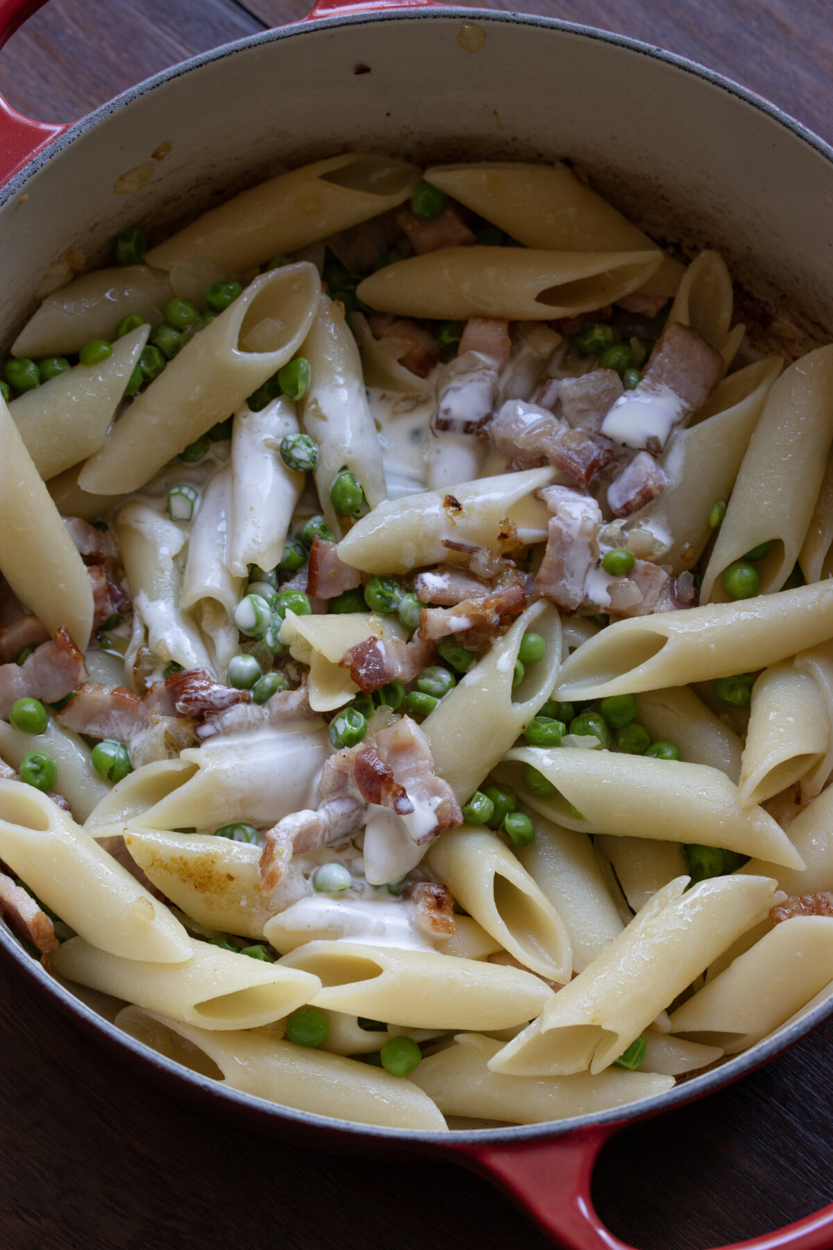 Heavy cream is added to the pasta skillet at low heat.