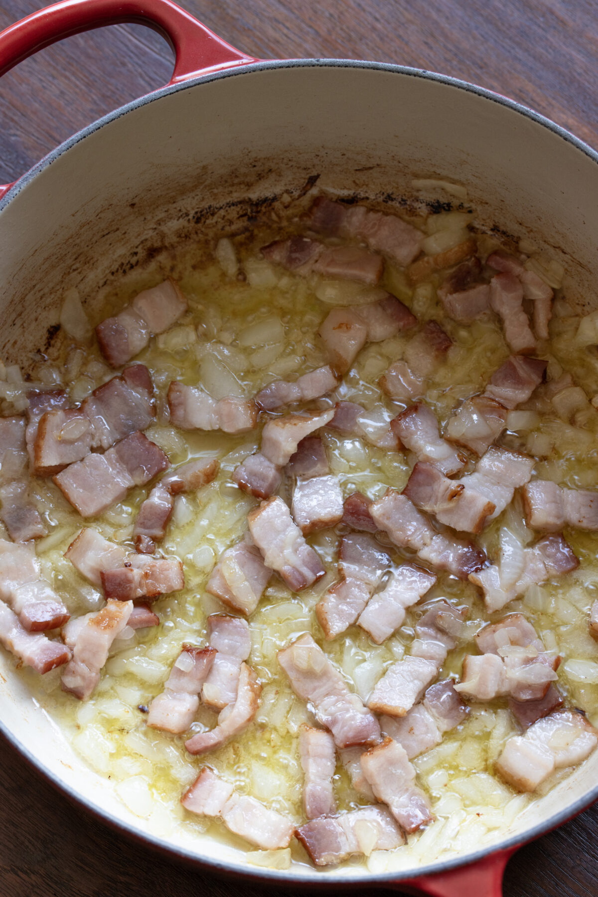 Bacon has been crisped and the onions are traslucent.