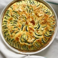 Zucchini feta quiche served on a white baking dish.