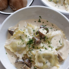 Ravioli with Creamy Mushroom Sauce served in a white pasta bowl.