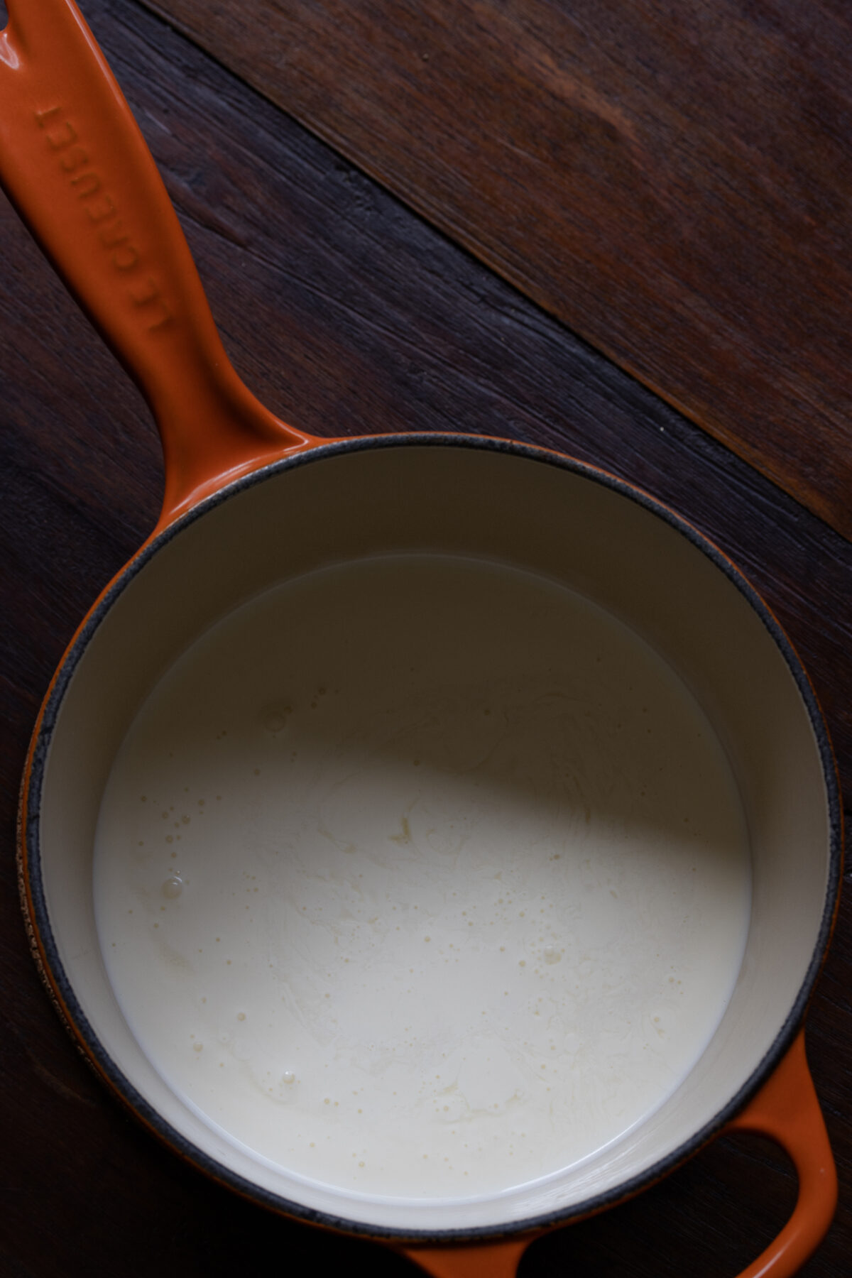 Added chicken stock and heavy cream to a saucepan.