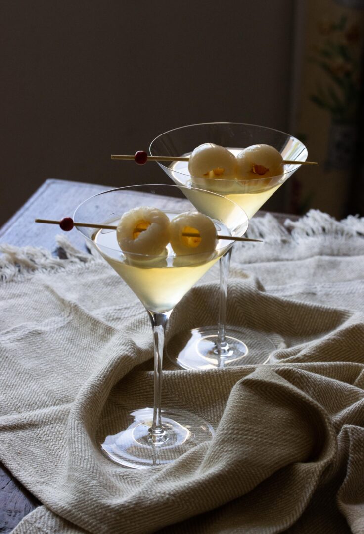 Two finished lychee martinis on the table. 