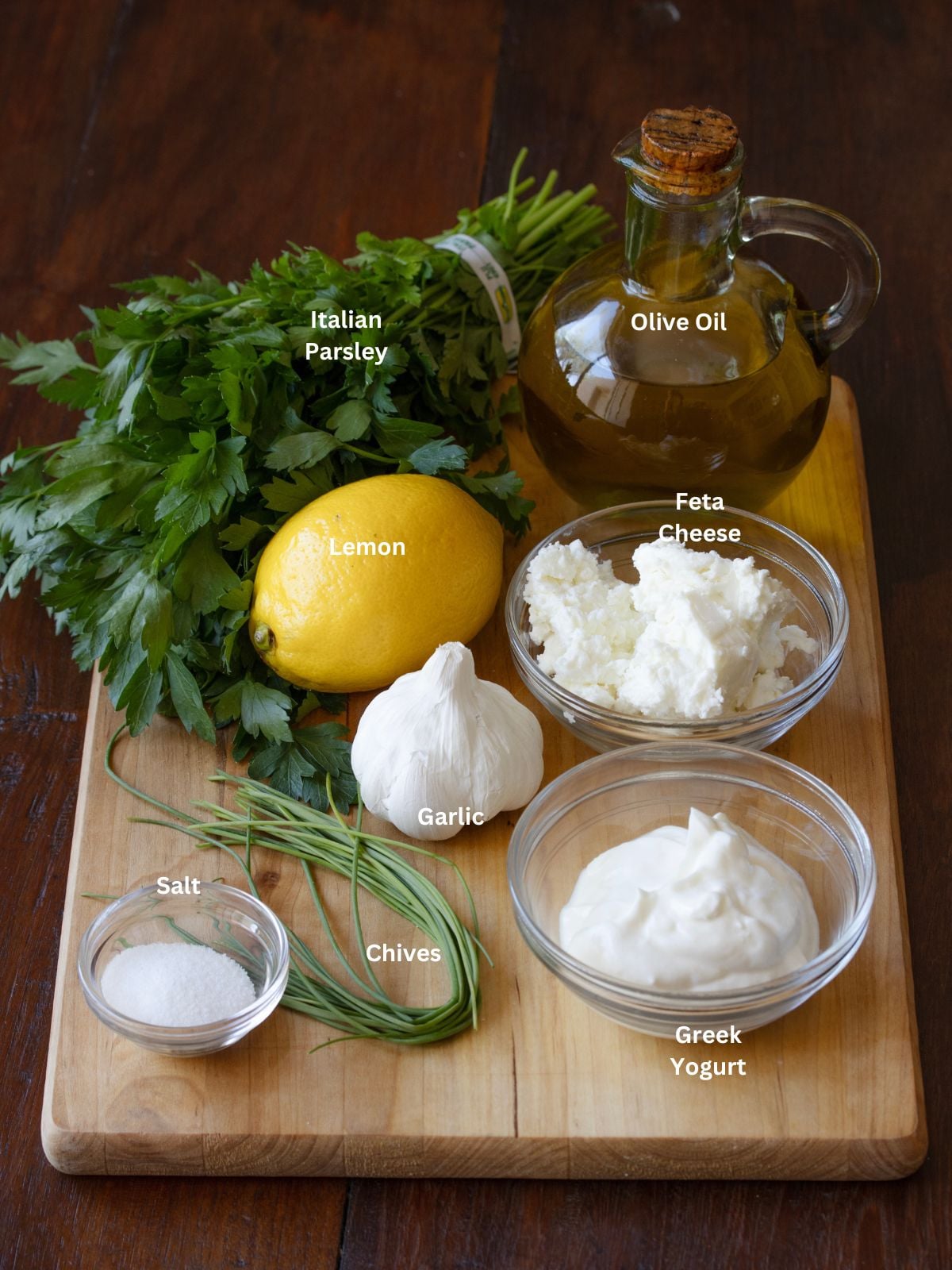 Ingredients needed to make yogurt feta sauce placed on a cutting board.
