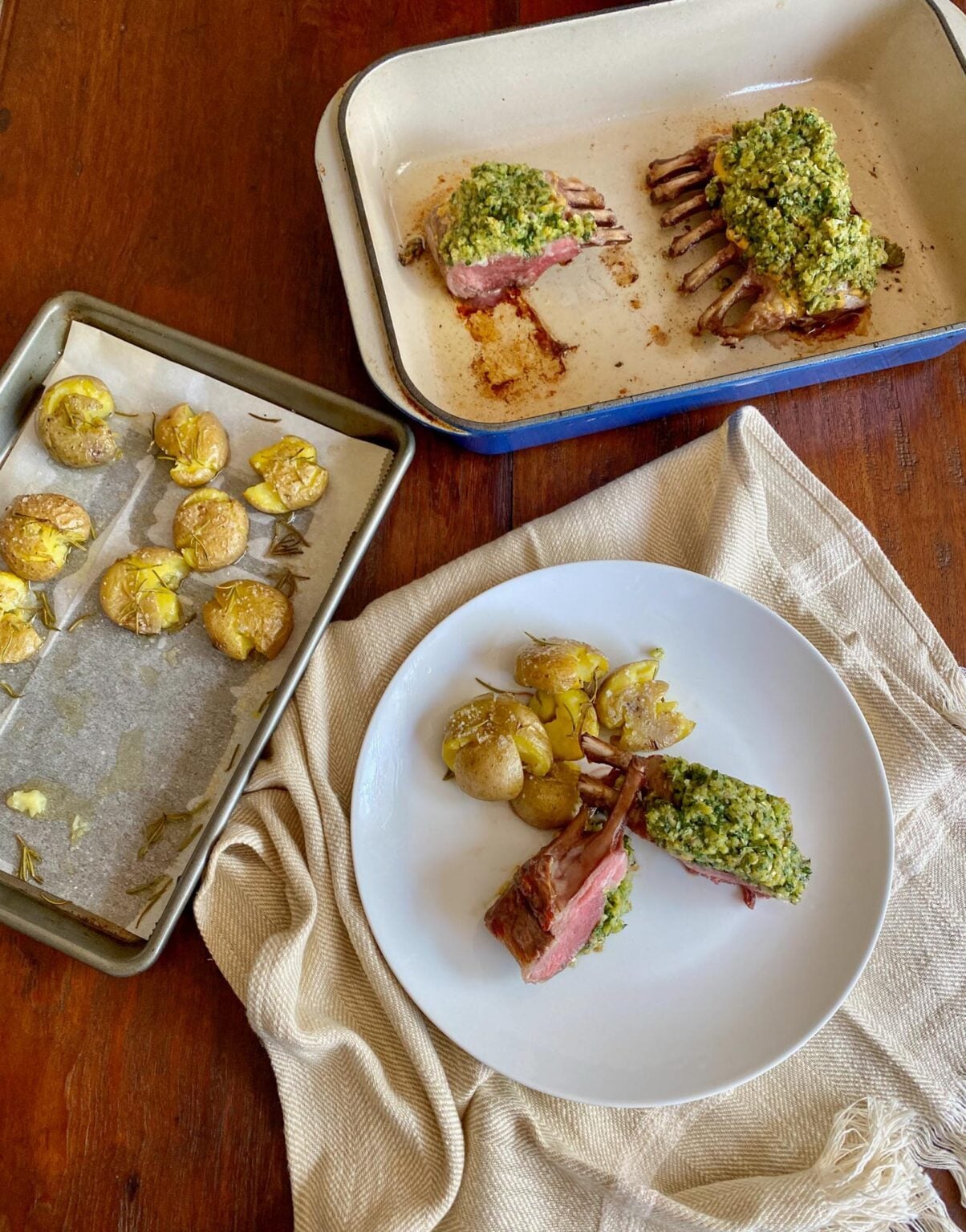 Rack of Lamb with Parsley served on a white place with potatoes on their baking sheet