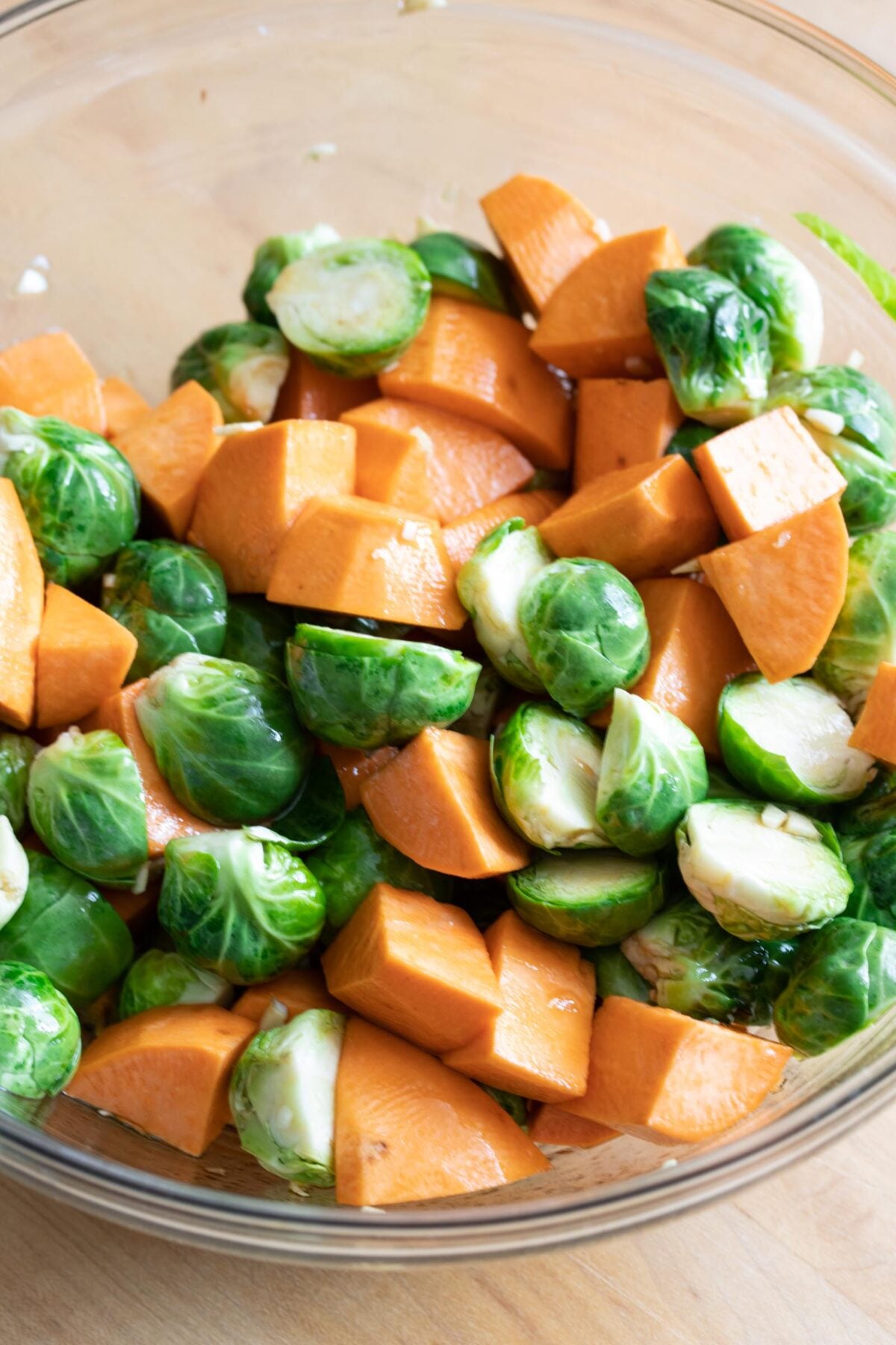 sweet potatoes and Brussels sprouts to the bowl. Season with salt and pepper, then toss well until all the vegetables are evenly coated with the maple balsamic mixture.