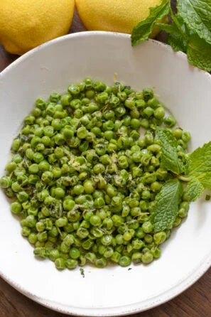 Mint Peas with Lemon and Butter served in a white round serving plate.