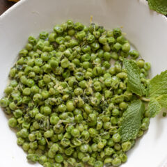 Mint Peas with Lemon and Butter served in a white round serving plate.