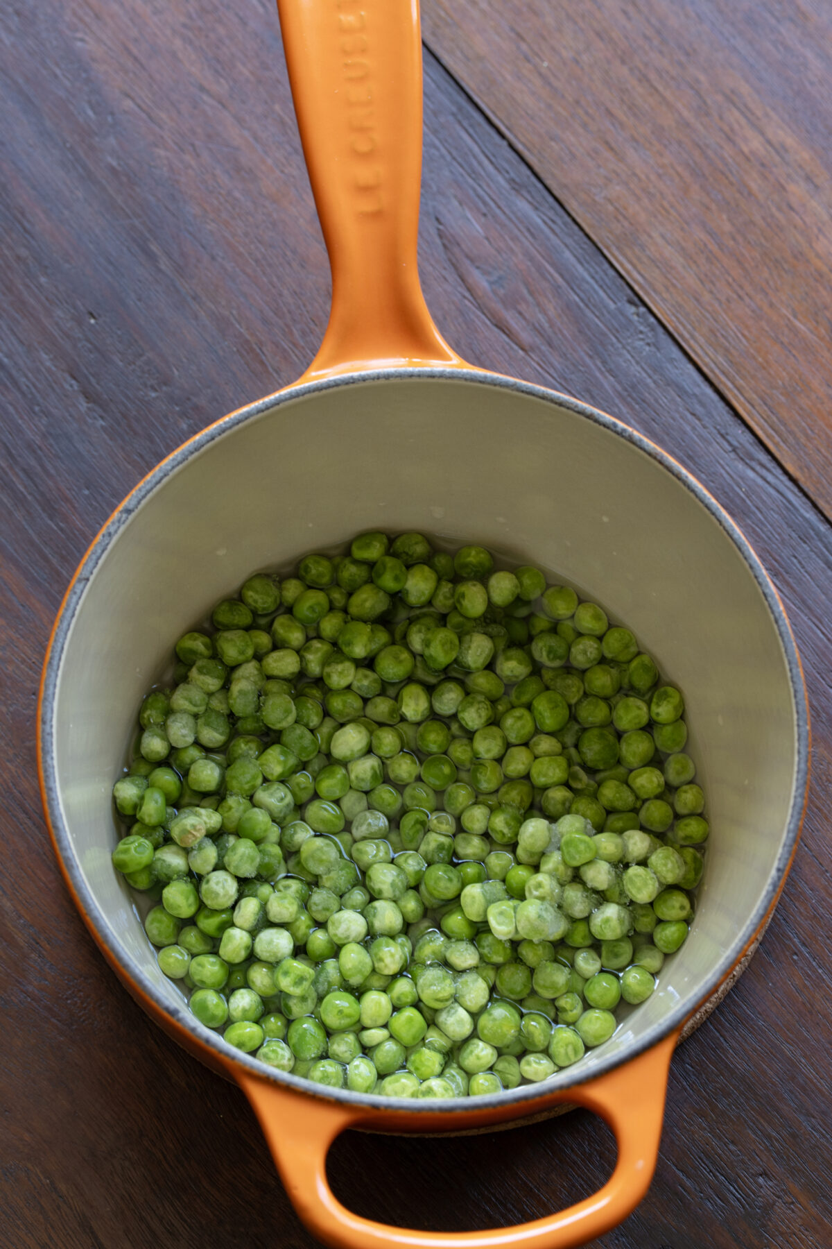 Peas with water placed in a small pan to bring to a boil.