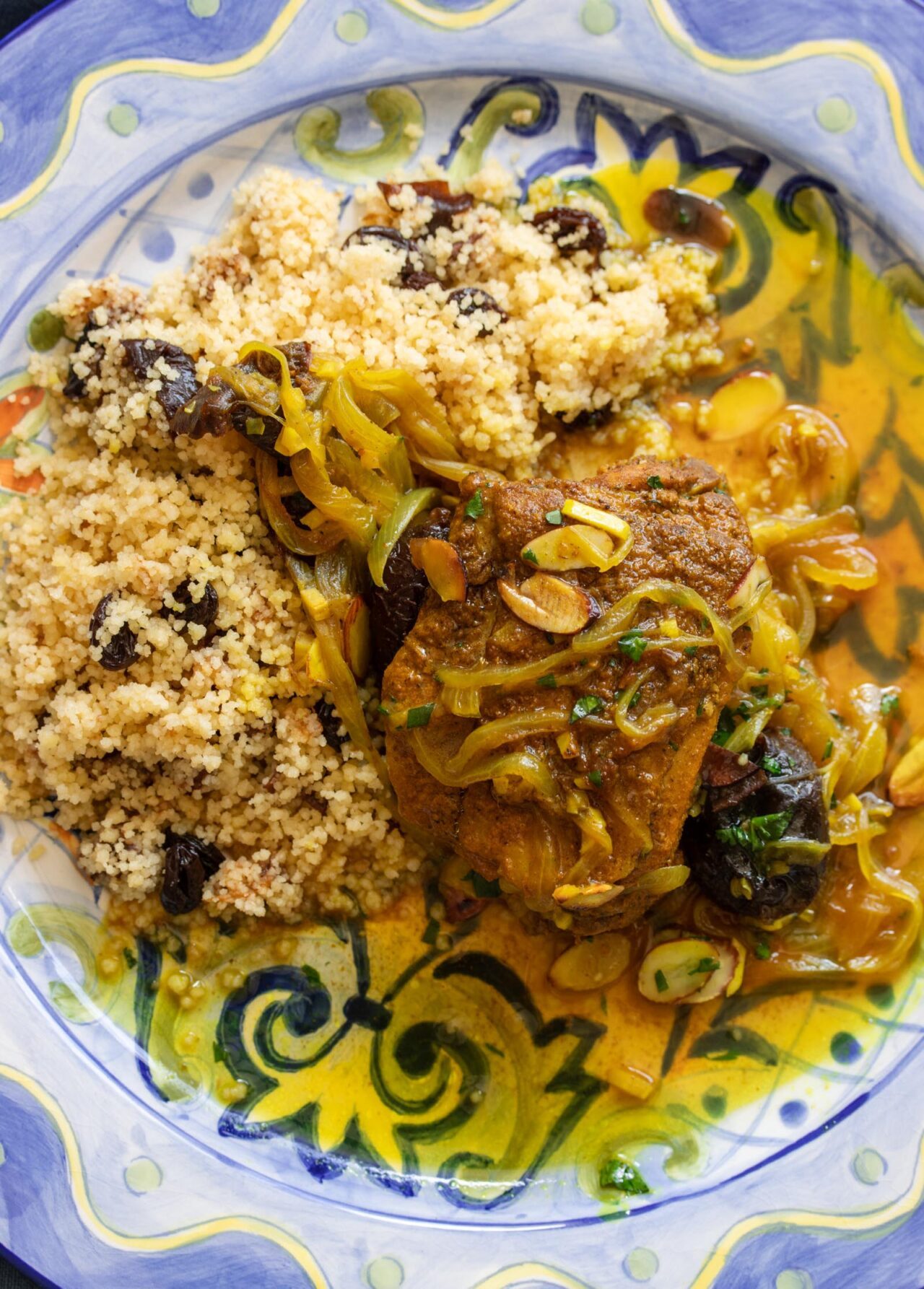 Moroccan Chicken and Prunes served on a blue and yellow serving dish