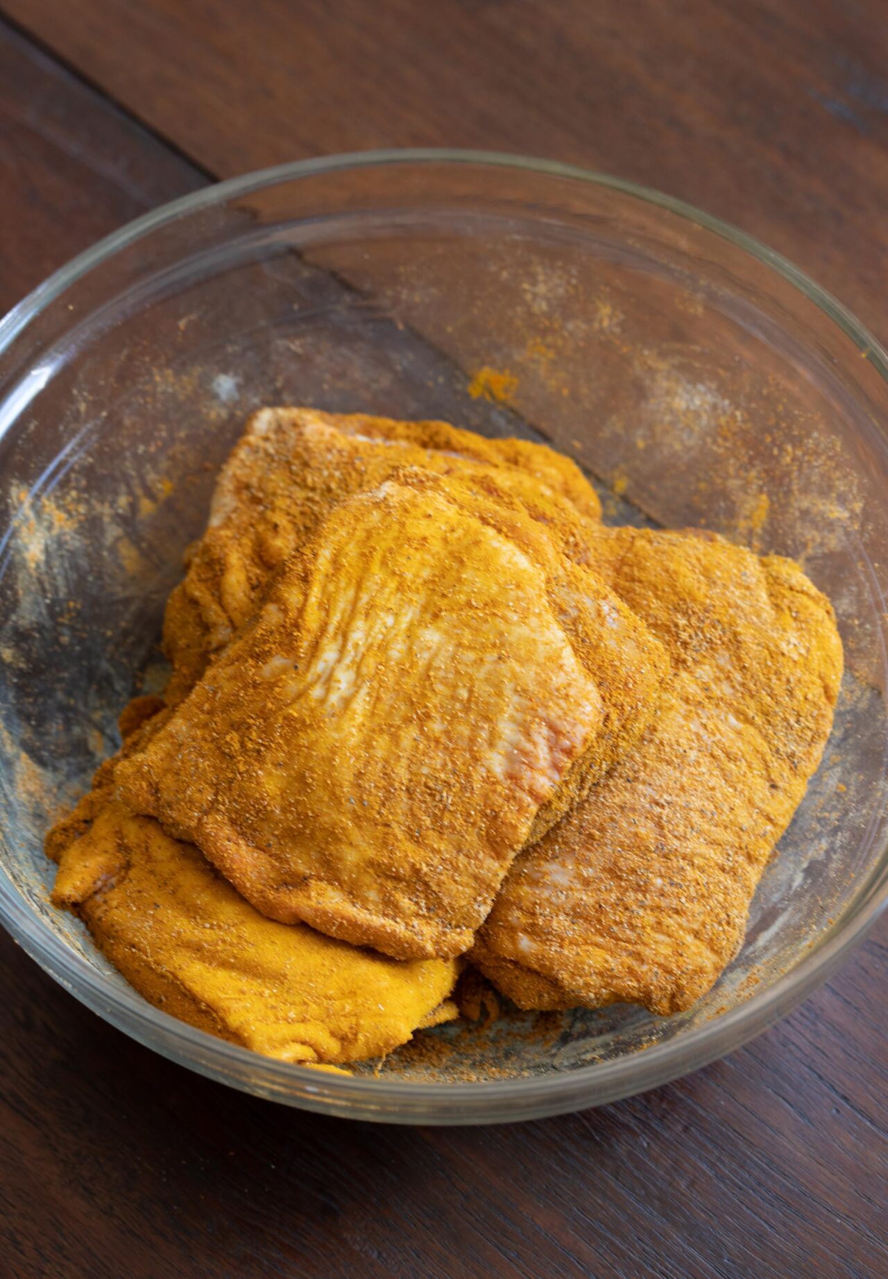 Marinating chicken with ground spices. 