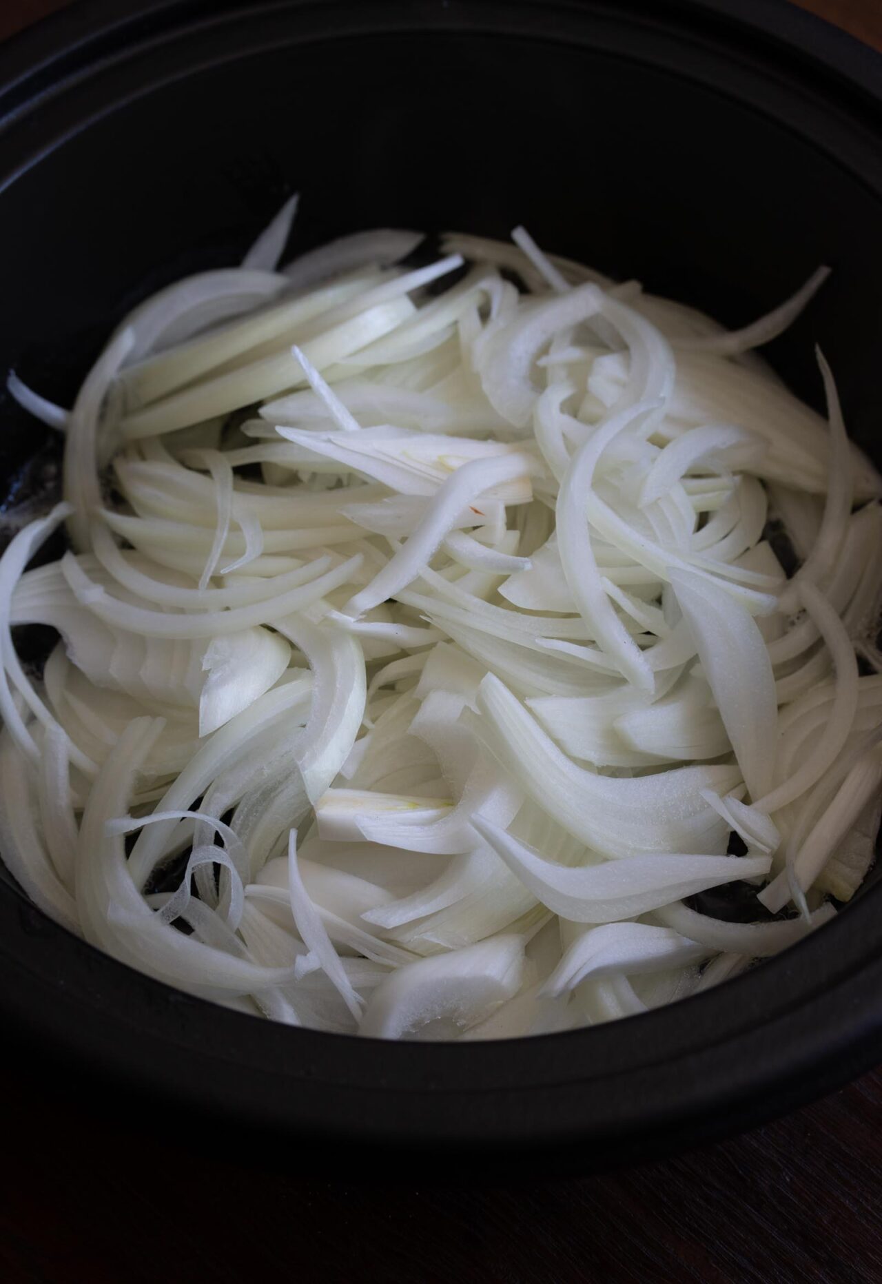 Sliced onions are placed on the bottom of the tagine.