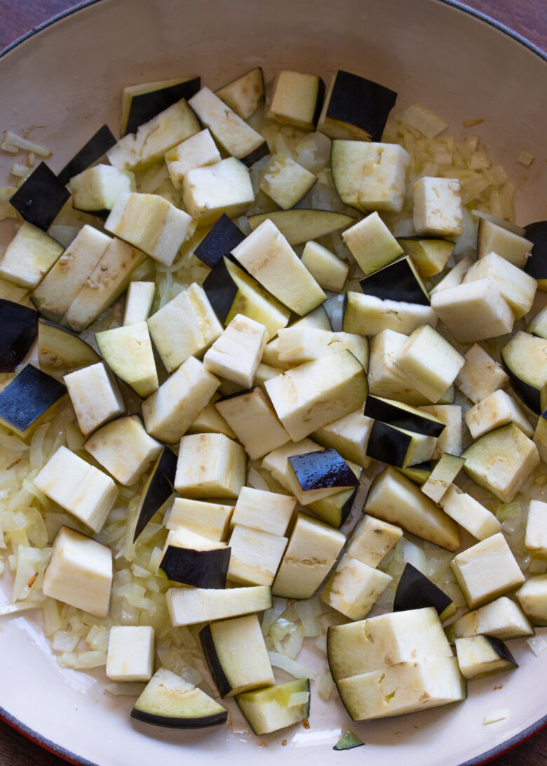 Eggplant added to the skillet with the translucent onions.