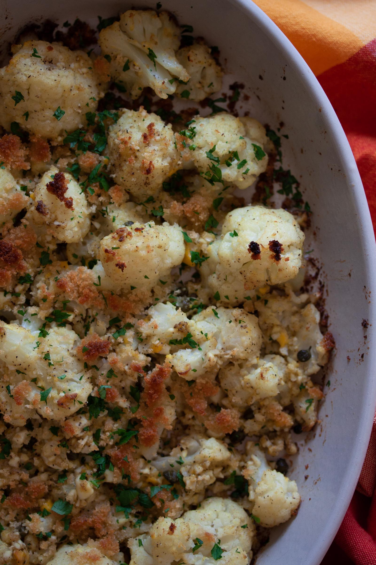 A close up of the finished cauliflower polonaise recipe in a baking dish.