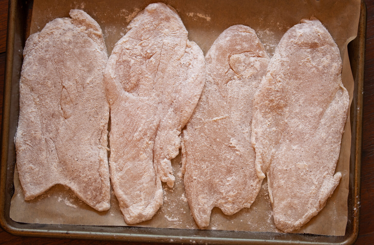 Seasoned chicken breasts on a tray. 