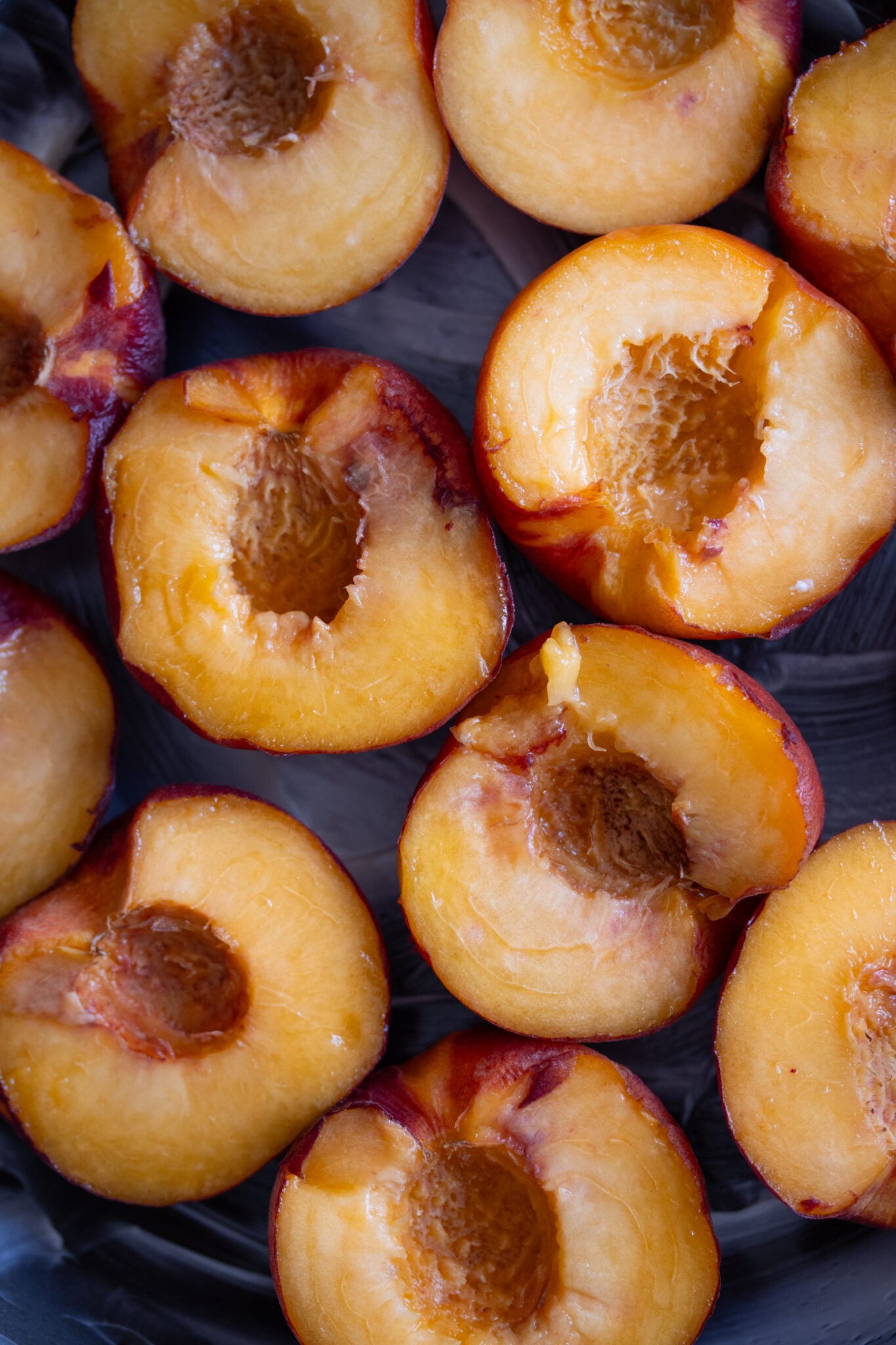 Fresh peaches cut in half with the pit removed.