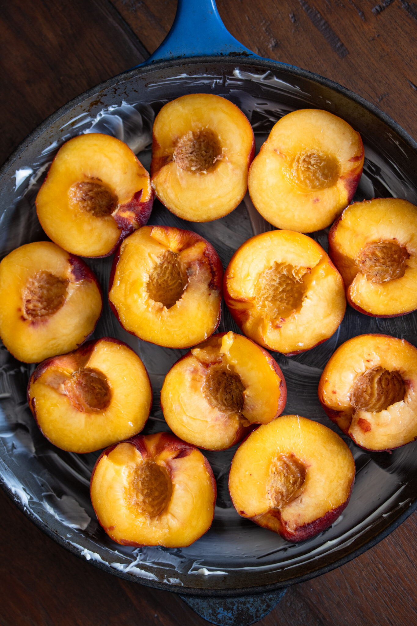 Fresh cut peaches arranged in a skillet.