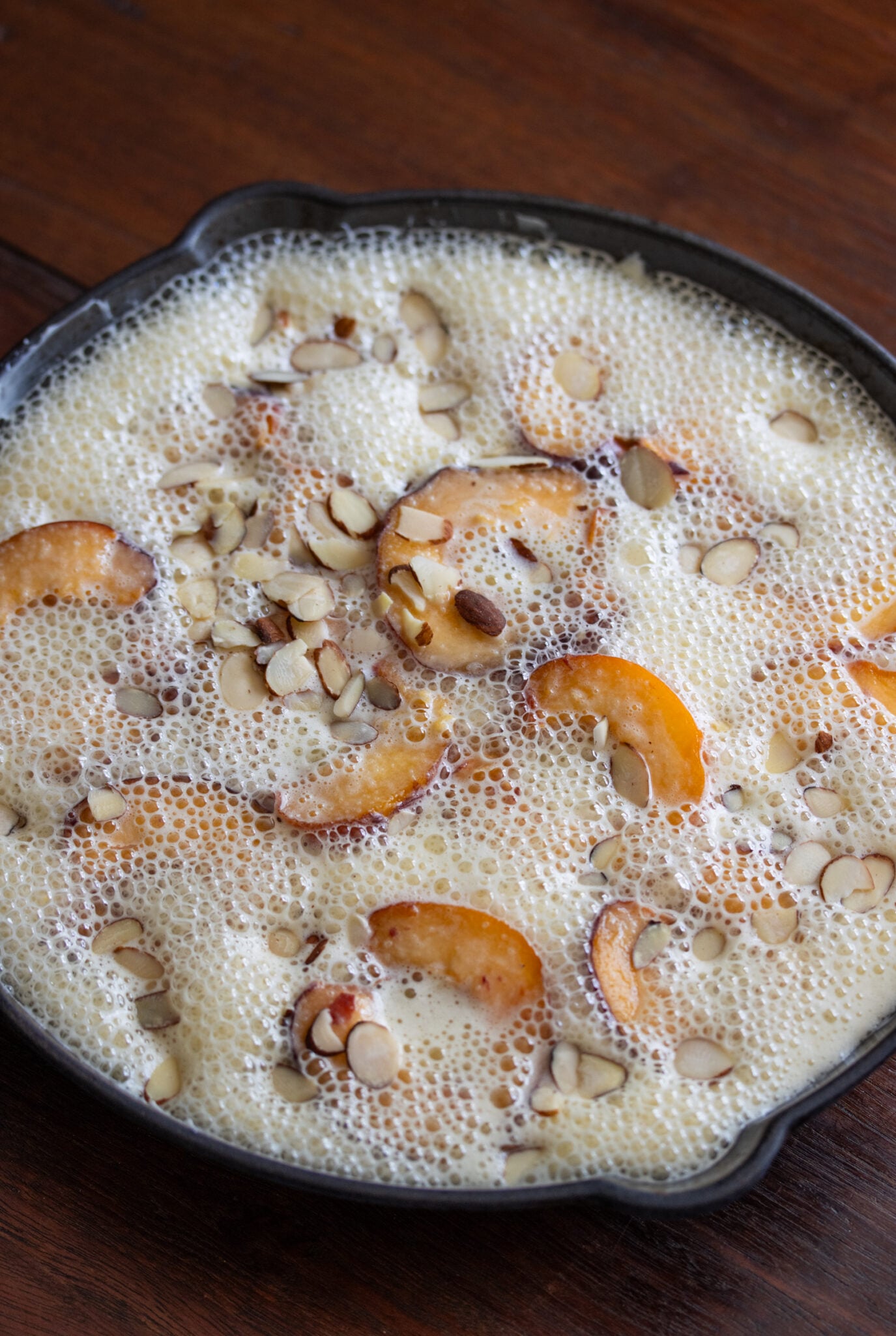 Peaches in the skillet covered with batter.