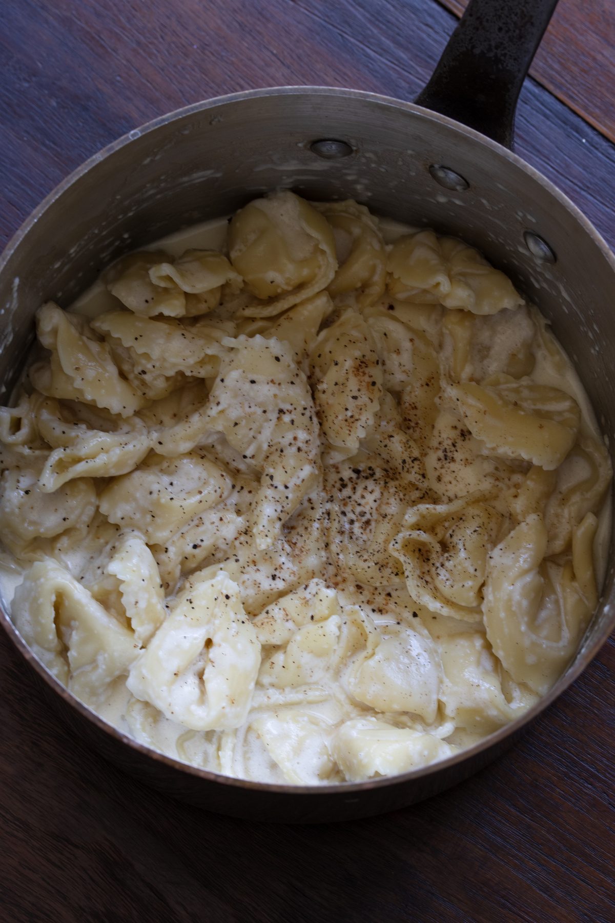 Grinds of black pepper and nutmeg added to the tortellini.
