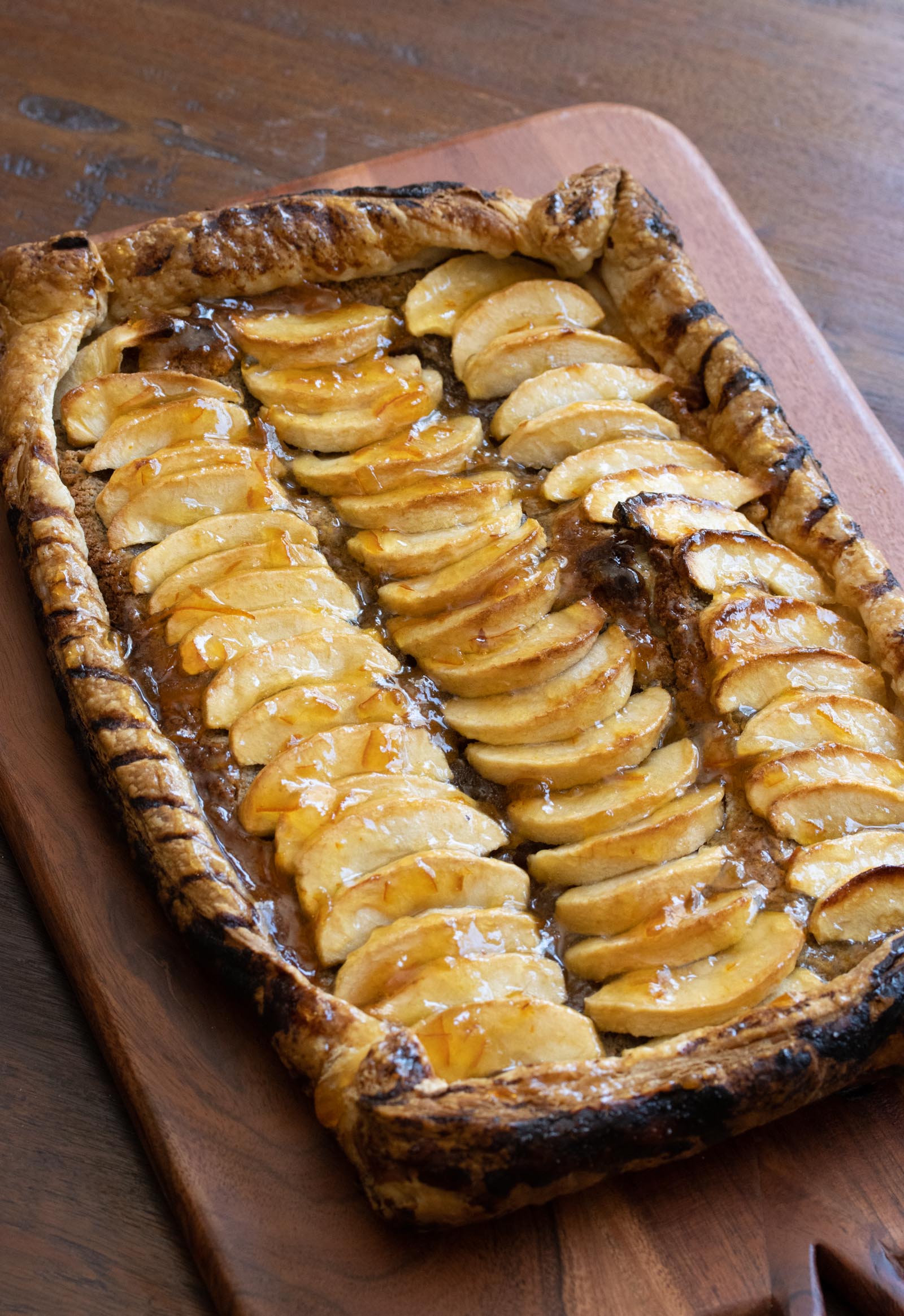 apple tart with hazelnut frangipane The finished recipe on a wooden cutting board.