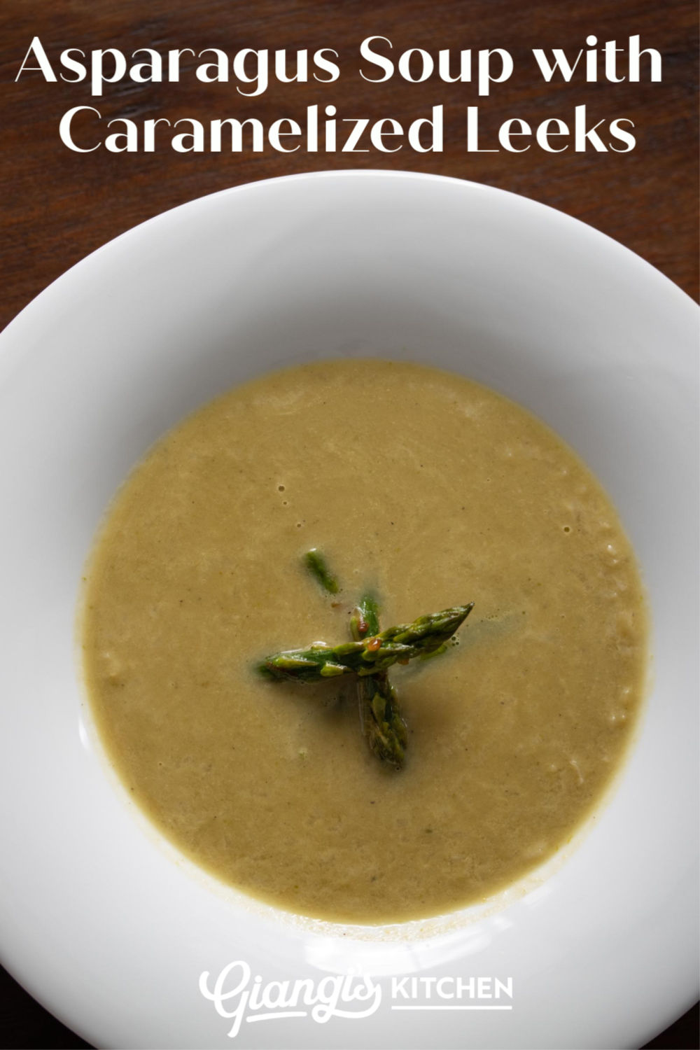 asparagus soup with caramelized leeks in a white plate on a brown wooden table