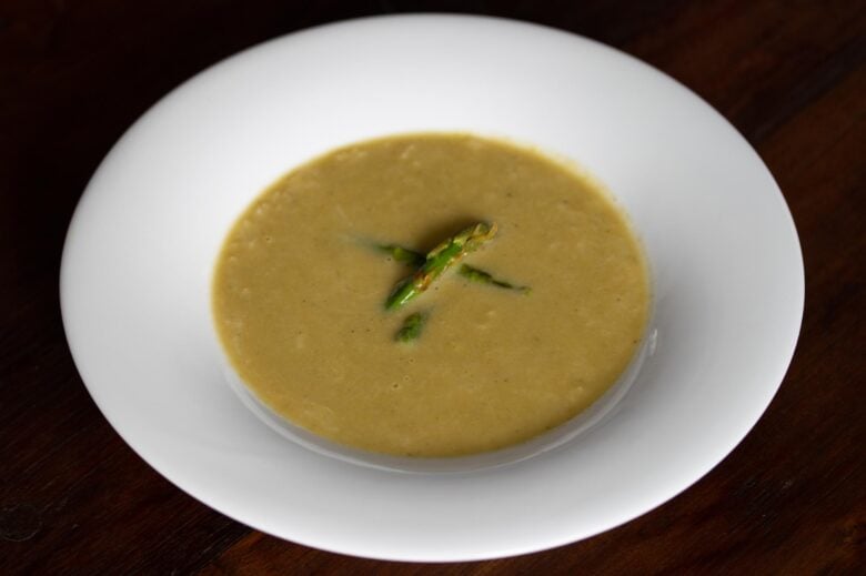 asparagus soup with caramelized leeks served on a white plate 