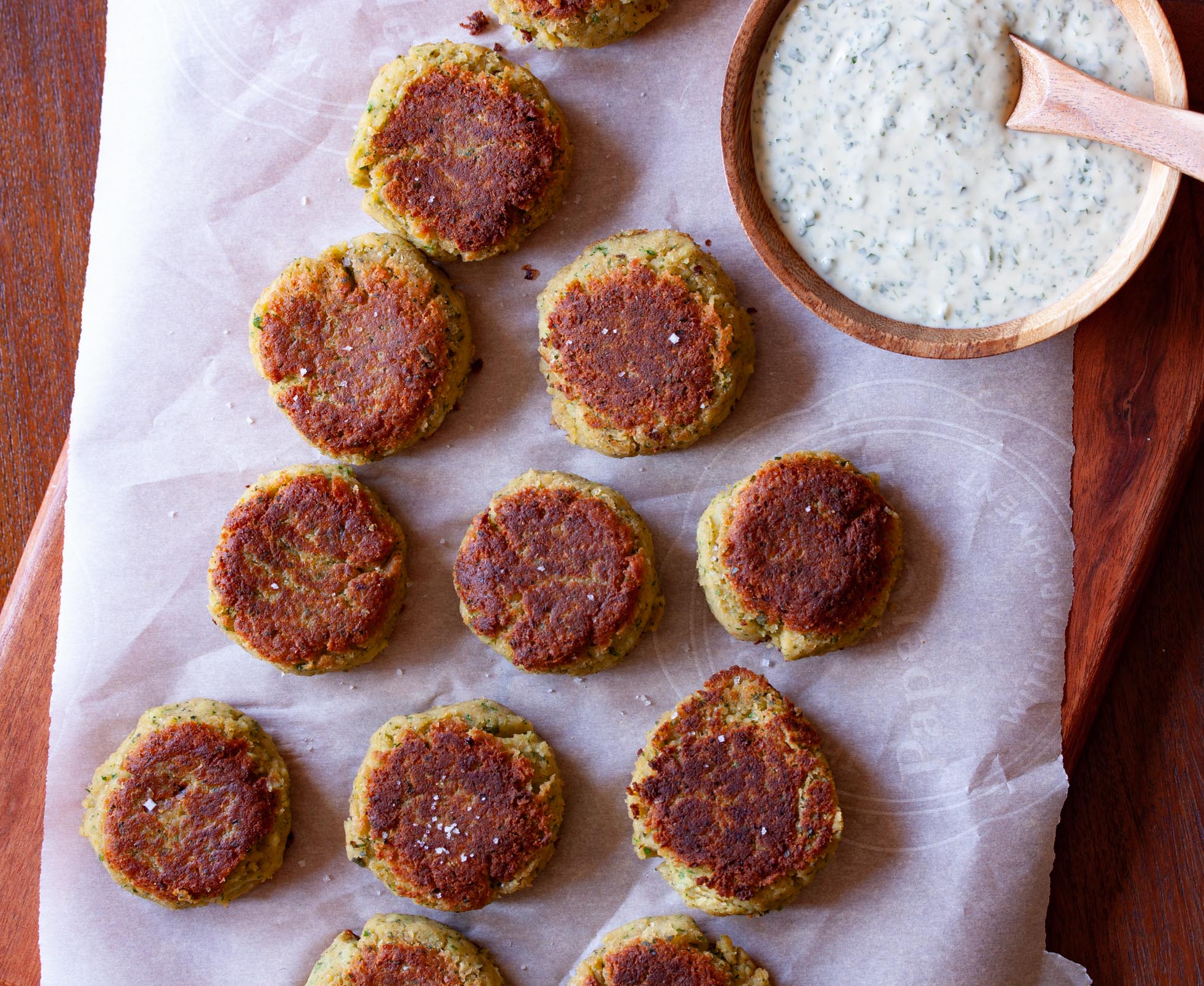 Garbanzo Beans Croquettes with Tahini Sauce on a wood cutting board